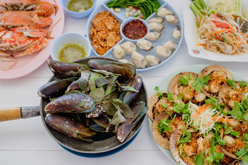 special Thai seafood (fish fried, Fried rice with crab, Crab's spawn salad, papaya salad, shrimp,Herb Roasted Mussels) on white table background. party concept.