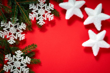 beautiful christmas white stars on a red background with twigs of spruce