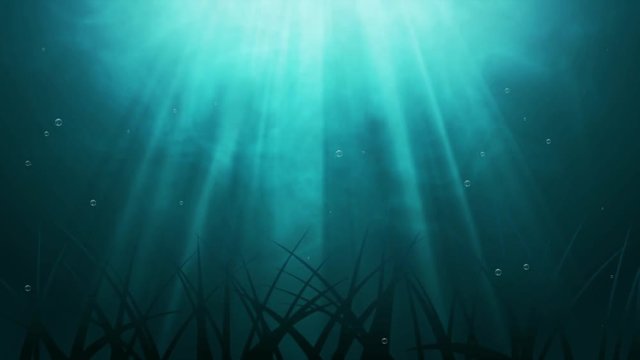 Dark blue ocean surface seen from underwater and rays of sunlight shining through