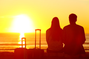 Couple of travelers looking at sun on vacation travel