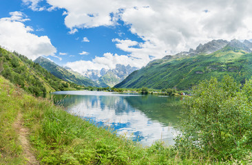 Fototapeta na wymiar Mountain lake between mountains and trees . Turquoise water and blue sky.