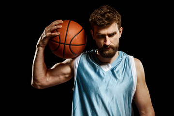 Muscular basketball player on black