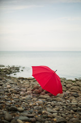 Loneliness Concept.  Red Umbrella Over Deserted Beach. Background. Copy Space Solitude Depression New start Procrastination.