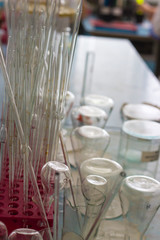 Glass flasks and pipettes closeup on desktop in medical laboratory.