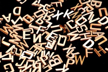a heap of wooden letters are lying in the dark studio