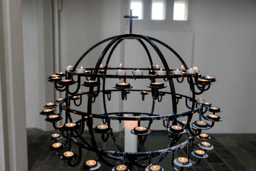Fototapeta na wymiar Burning candles on a chandelier in the church