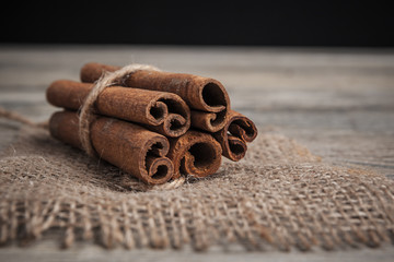 Cinnamon sticks on wooden background.