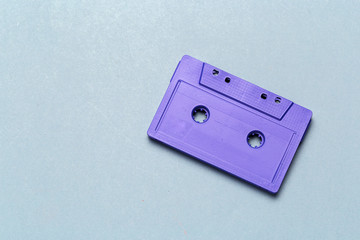 One single retro audio cassette on light grey background, top view