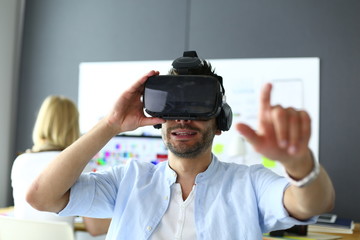 Young male software programmer testing a new app with 3d virtual reality glasses in office.