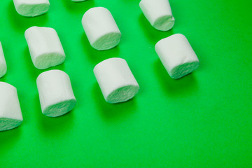 sweet marshmallow, candy on green background, top view