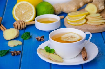 Ginger tea with lemon and honey on blue wooden background