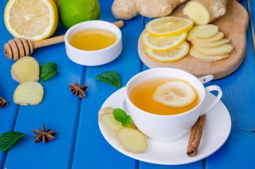 Ginger tea with lemon and honey on blue wooden background