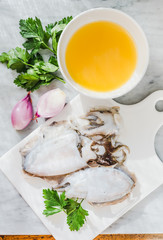 Fresh cuttlefish and ingredients for preparing cooking with squids or cuttlefish, parsley and broth.