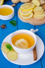 Ginger tea with lemon and honey on blue wooden background