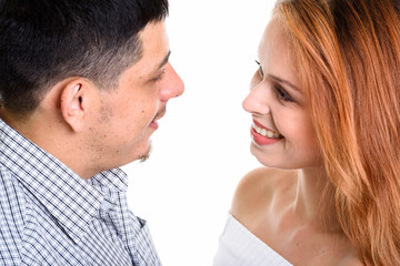 Young Hispanic couple smiling and looking at each other in love