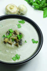 Mushroom cream soup with parsley in a black bowl