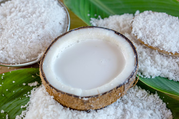 Fototapeta na wymiar fresh coconut milk in coconut bowl on green leaf background 