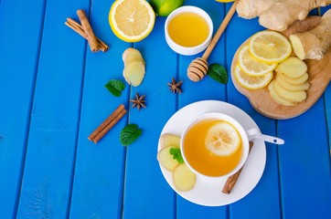 Ginger tea with lemon and honey on blue wooden background
