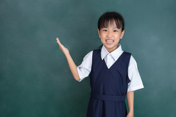 Asian Chinese little girl standing in front of green blackboard