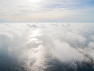 Aerial view White clouds in blue sky. Top view. View from drone. Aerial bird's eye view. Aerial top view cloudscape. Texture of clouds. View from above. Sunrise over the sea