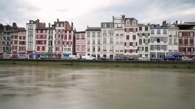 Time lapse old houses with half-timbered facades in the city of Bayonne. Cloudy weather. View on the banks of La Nive, where there is traffic. Filmed in October 2018. 