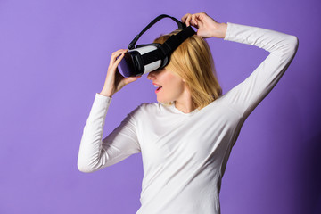 Girl use modern technology vr headset. Enjoy virtual reality. Woman hold vr headset glasses violet background. Digital device and modern opportunities. Virtual reality and future technologies