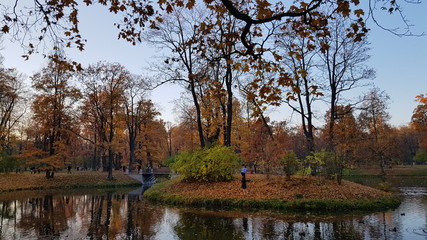 Autumn Park with an island and canals and people walking