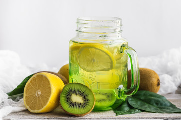 Water with lemon and kiwi in a glass jar.