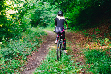 Fototapeta na wymiar young woman on bicycle in forest
