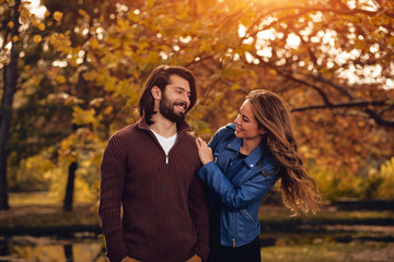 Couple in autumn season colored park enjoying outdoors.