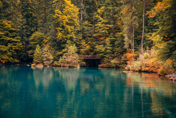 Autumn time at romantic forest lake Blausee, Switzerland.