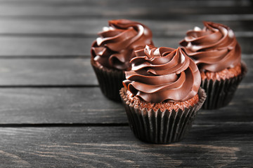 Delicious chocolate cupcakes on wooden table