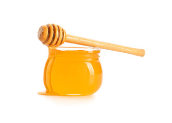 Jar of honey with dipper on white background
