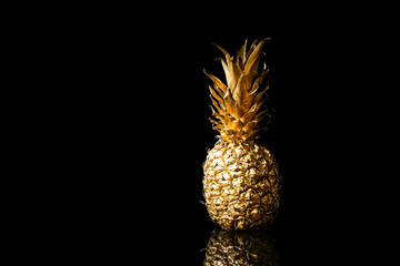 Golden pineapple on black background