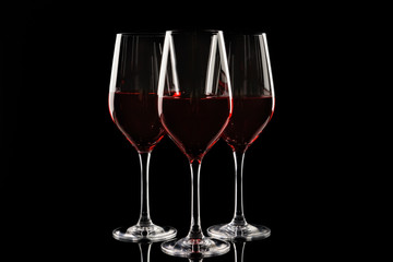 Glasses of red wine on dark background