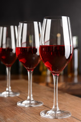 Glasses of red wine on wooden table