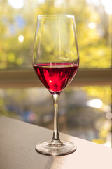 Glass of red wine on table