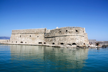 Venetian fort at Heraklion harbor under blue sunny sky in summer time, Crete Island, Greece