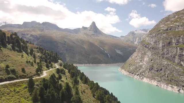 a Swiss reservoir in the Alps with a striking mountain peak in the background