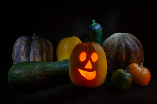 smiling halloween pumpkins in black background with light painting