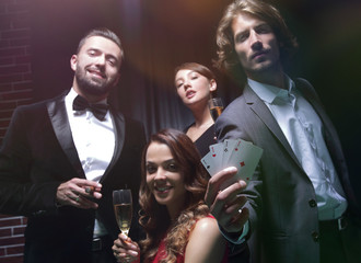 Four people toasting with champagne at roulette in casino