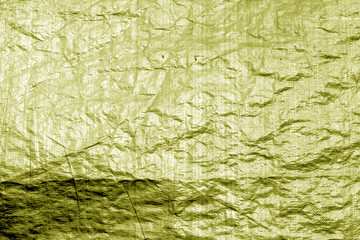 Crumpled transparent plastic  surface in yellow color.