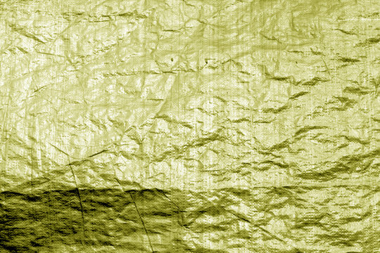 Crumpled transparent plastic  surface in yellow color.