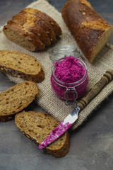 Beetroot spreads on dark, whole-grain bread in village style. healthy dinner or snack concept.