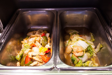 hotel restaurant food catering service buffet banquet for wedding ceremony, seminar, meeting, conference, party event. mixed fried vegetable with chicken and cabbage fried with shrimp in chafing dish