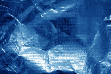 Crumpled plastic textile texture in navy blue color.
