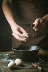 hands are breaking an egg