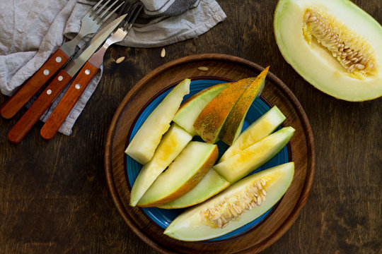Melon. Fresh sliced melon in  a plate on  the wooden table. Top view flat lay background. Copy space.