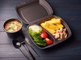 Lunch boxes with food ready to go for work or school, or dieting concept, delicious soup, vegetables and cheese