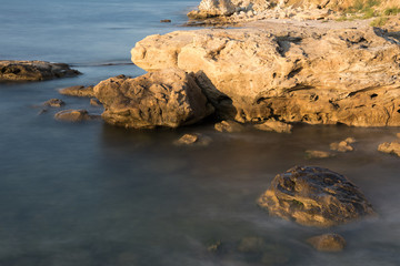 The wild sea beach with stones at sunrise. Bulgaria